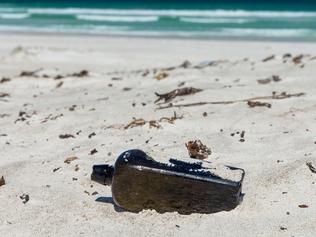 A supplied image obtained on Tuesday, March 6, 2018, of the world?s oldest known message in a bottle which has been found half-buried at a West Australian beach nearly 132 years after it was tossed overboard into the Indian Ocean. The bottle had been flung from the German sailing barque "Paula" in 1886 as part of a 69-year official experiment to better understand global ocean currents and find faster, more efficient shipping routes. (AAP Image/supplied/Kym Illman) NO ARCHIVING, EDITORIAL USE ONLY