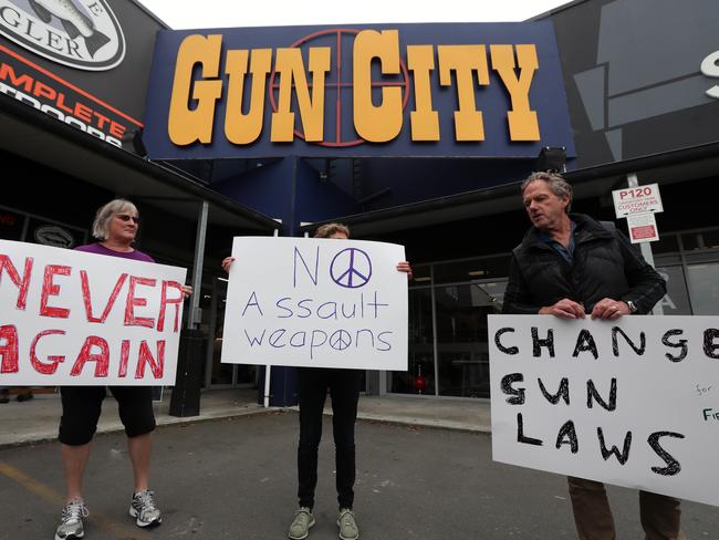 Protestors stood at the front of the gun shop in protest to New Zealand's current gun laws. L-R: Reina Doran, Jill Nadler and Michael Sim with a random gun owner (name withheld). Picture Gary Ramage