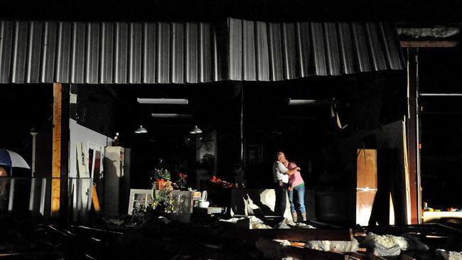Destroyed ... Jeff and Melissa McKenzie embrace in the ruins of their florist and gift shop store in Columbia, Mississippi, after a tornado ripped through the city. Picture: AP Photo/The Hattiesburg American, Eli Baylis