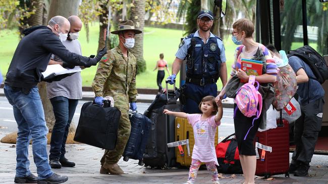 Security officers check passengers as they arrive at a city hotel after landing at Sydney Airport on Sunday. Picture: Jane Dempster