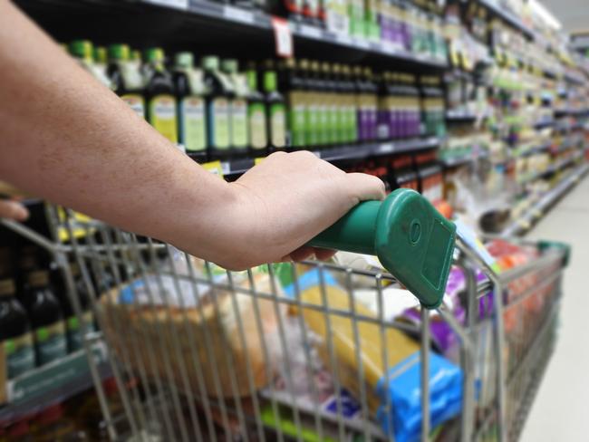 Woman hands pushing a shopping trolley in a supermarket.