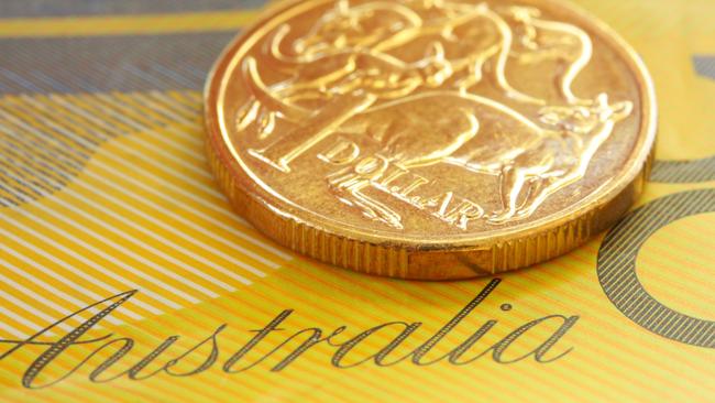 Australian one dollar coin on a fifty dollar note.  Close-up view, with shallow depth of field; generic money