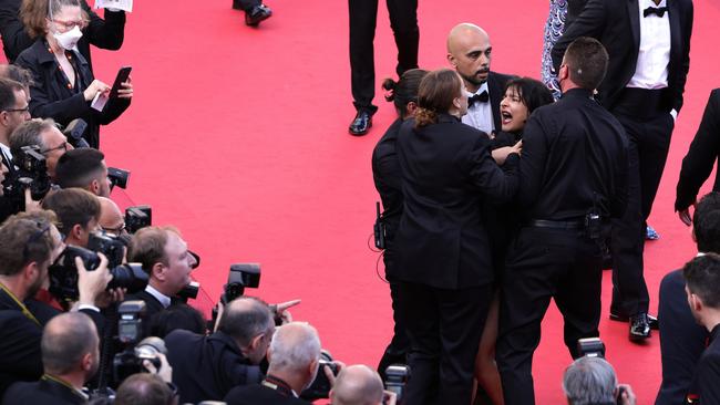 Security covered the protester and removed her from the red carpet. Picture: Andreas Rentz/Getty Images