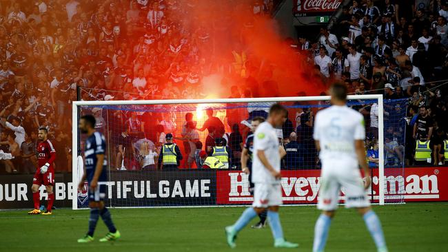 A flare is lit during the Melbourne derby.