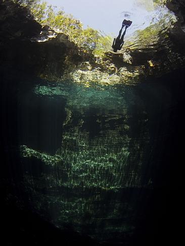 A woman free diving in a blue hole in the Bahamas.