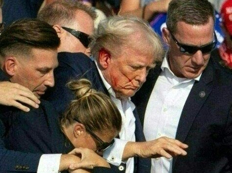 Republican candidate Donald Trump is seen with blood on his face surrounded by secret service agents as he is taken off the stage at a campaign event at Butler Farm Show Inc. Picture: AFP