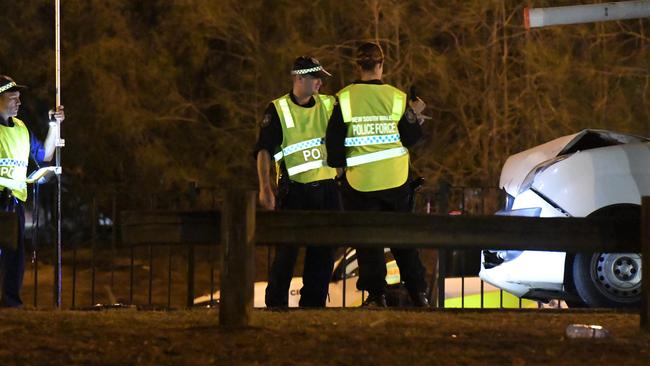 Police examine the scene where their colleagues were injured. Picture: Gordon McComiskie