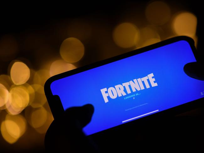 This file illustration photo taken on August 14, 2020 shows a person logging into Epic Games' Fortnite on their smartphone in Los Angeles. (Photo by Chris DELMAS / AFP)