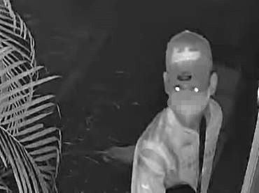 CCTV shows masked intruder in a No. 9 jersey using a lighter to break in through a window as the family sleeps inside.