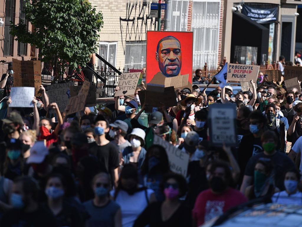 Protesters hold up signs and a portrait of George Floyd. Picture: Angela Weiss/AFP