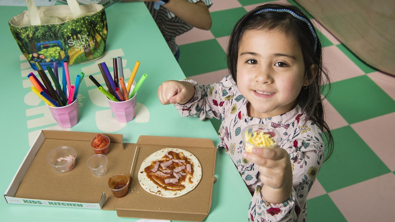 Aria Chong Nee assembles her pizza at the Kids in the Kitchen school holiday activity at Grand Central, Monday, January 16, 2023. Picture: Kevin Farmer