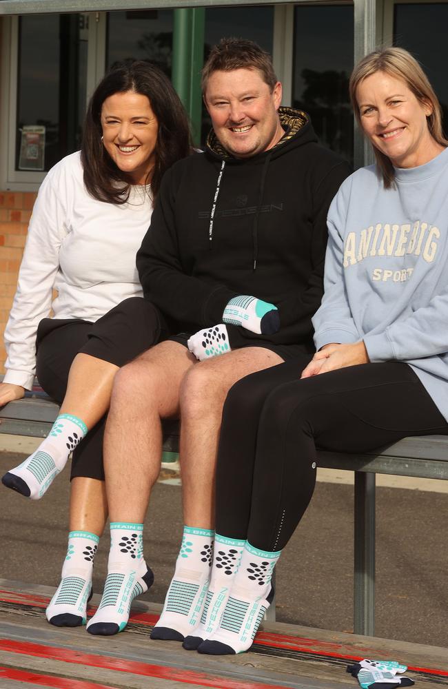 GSMC director Emma Jarman, left, Steigen general manager Nick Chandley and widow Katie McMahon and with the Australian Sports Brain Bank fundraising socks. Picture: Alison Wynd