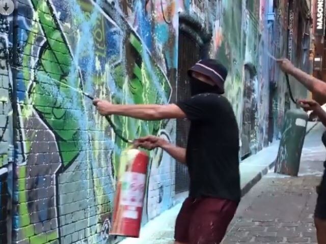 Screen grabs of masked individuals spray painting over graffiti art in Hosier Lane over the weekend. Picture: instagram @ joe_musco