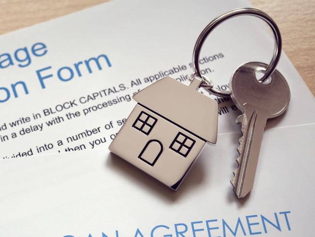 Mortgage loan agreement application with  key on house shaped keyring