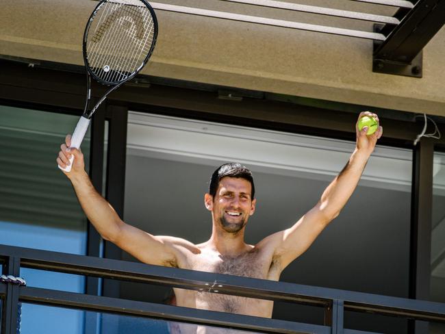 Men's world number one tennis player Novak Djokovic of Serbia waves to fans from a hotel balcony in Adelaide. (Photo by Morgan SETTE / AFP).