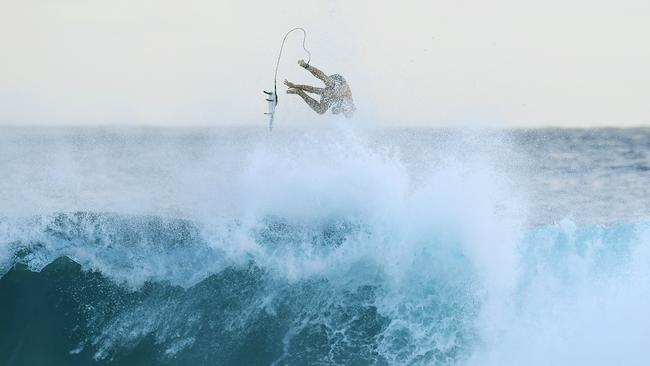 A surfer is seen at Snapper Rocks on the Gold Coast, Thursday February 21, 2019. Huge swells and high tides are set to pummelling southeast Queensland beaches over the coming days as Cyclone Oma tracks towards the Queensland coast. (AAP Image/Dave Hunt)