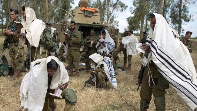 Israeli soldiers of the Jewish Ultra-Orthodox battalion “Netzah Yehuda” hold morning prayers as they take part in their annual unit training in the Israeli annexed Golan Heights, near the Syrian border in May, 2014. Picture: Menahem Kahana/AFP via Getty Images