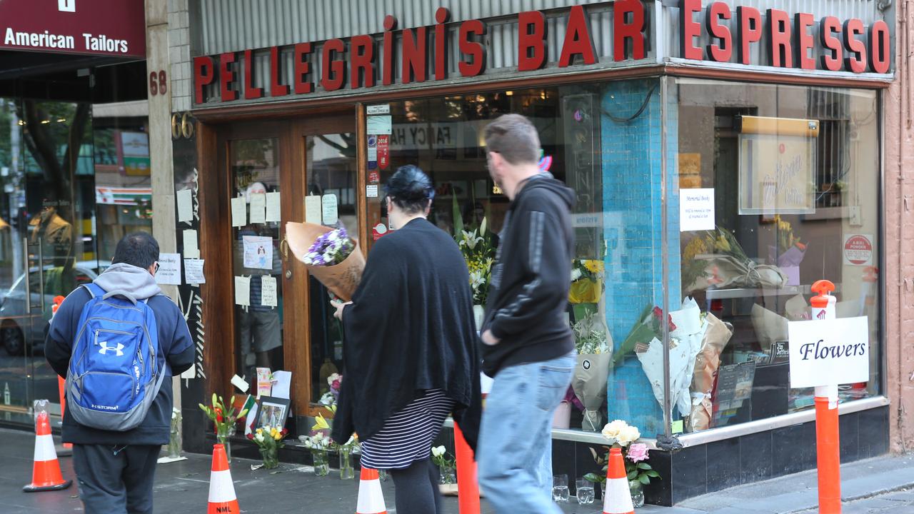 Mourners place flowers at the scene. Picture: David Crosling