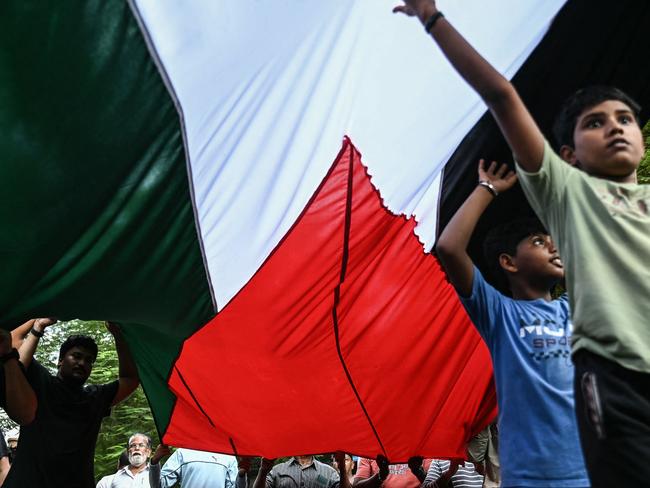 Shiite Muslims carry palestinian flag during a peace rally to condemn the killing of Hassan Nasrallah, late leader of the Lebanese group Hezbollah, by an Israeli air strike in Lebanon, in Chennai October 5, 2024. (Photo by R.Satish BABU / AFP)