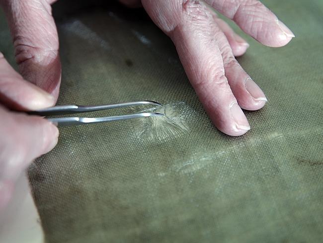 “Visually exciting” ... Specialist textile curator Liz Rose at the Imperial War Museum workshop working on the flag from the AIF's 12th Battalion 3rd Brigade who stormed Gallipoli in 1915. Picture: Ella Pellegrini