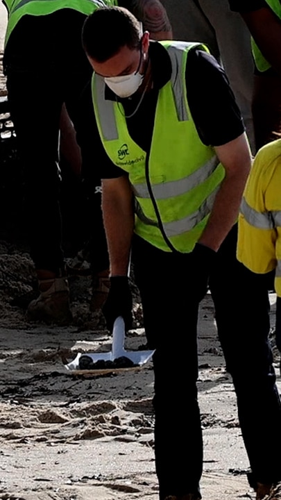 Workers clean up Coogee Beach after it was closed due to some unidentified pollution