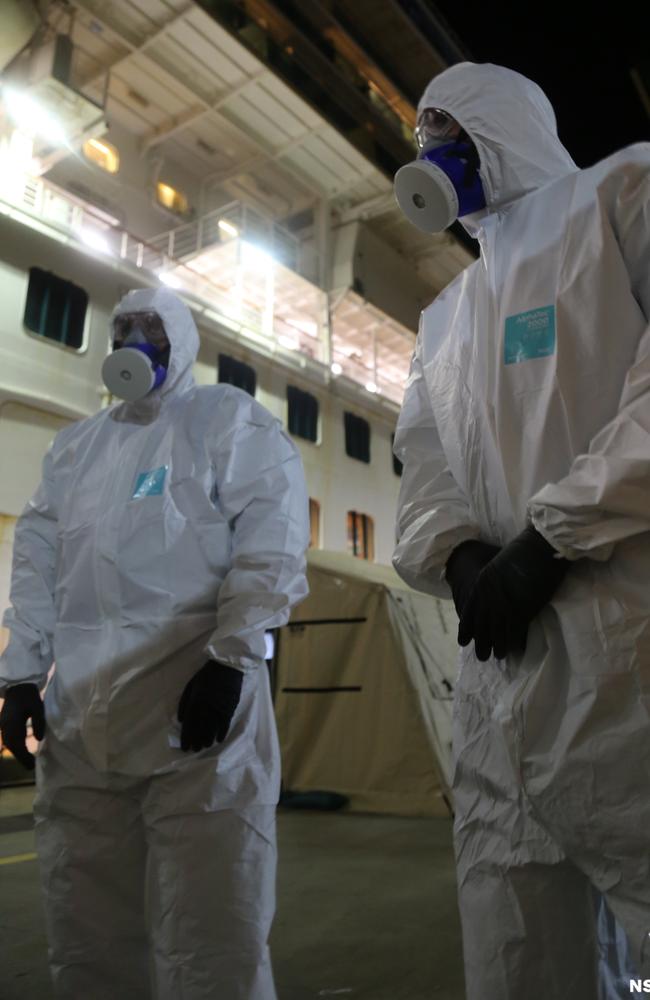 NSW Police detectives are seen in personal protective equipment outside the Ruby Princess cruise ship at Port Kembla at Wollongong on Wednesday. Picture: AAP Image/NSW Police