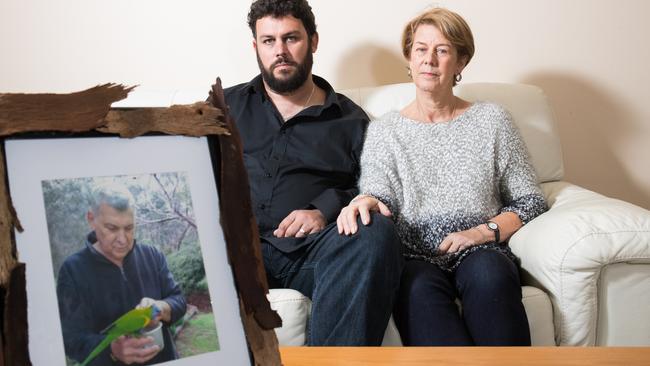 Clive and Barb Spriggs in their family home in Bellevue Heights with a photo of father and husband Bob Spriggs who was mistreated at Oakden. Picture: Matt Loxton