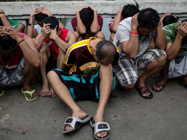 Drug suspects are rounded up during an anti-illegal drugs operation at an informal settlers’ community at the Manila Islamic Center in Manila on October 7, 2016.  Philippine President Rodrigo Duterte told all his critics to "go to hell" on October 6, as he renewed his threats to kill, after a poll showed Filipinos overwhelmingly endorsed his deadly war on crime.  / AFP PHOTO / NOEL CELIS