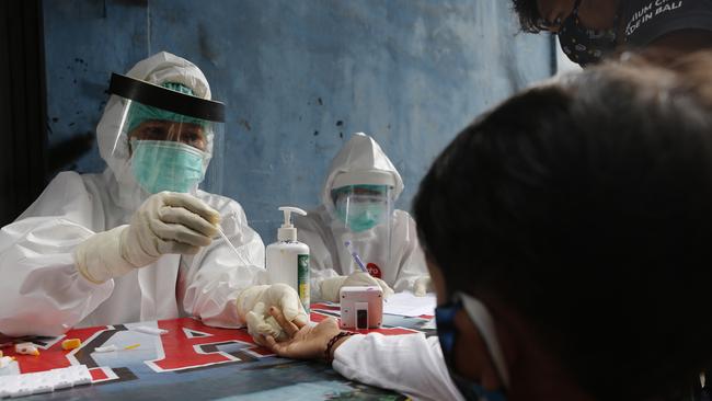 A boy waits to receive a coronavirus antibody test from health workers at a village in Bali this week. Picture: AP