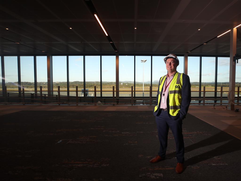 CEO Chris Mills stands in front of windows with stunning views of the hinterland and airfield. Picture: Glenn Hampson.