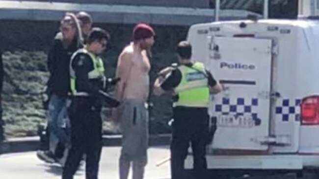 A topless man in handcuffs freely walked from Swanston Street police station before panic set in.