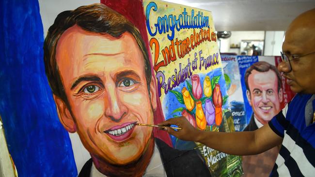 An artist gives final touches to a painting of French President Emmanuel Macron after his victory. Picture: AFP