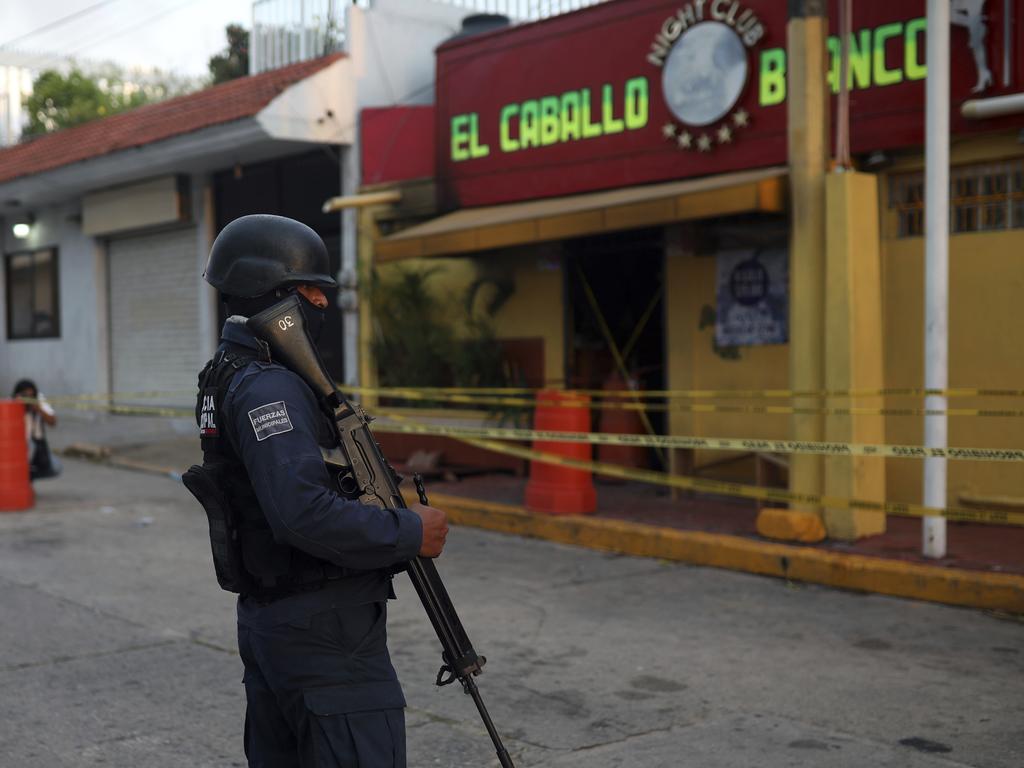 A police officer guards the scene outside a bar where more than 20 people died in an overnight attack, in Coatzacoalcos, Mexico. Picture: AP