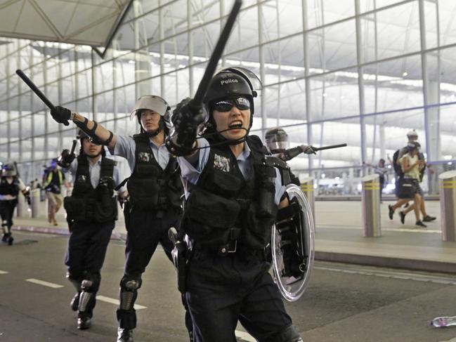 Police with batons and shields shout at protesters during a demonstration at the Chek Lap Kok Airport in Hong Kong. Picture: AP