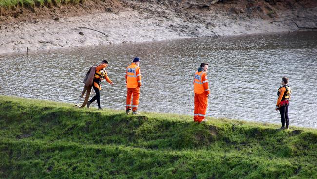 SES volunteers on the edge of the dam at Echunga after a night of reducing the water levels. Picture: Kelly Barnes