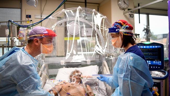 ICU nurse Michelle Spiteri and anaesthetist and intensive care physician Dr Forbes McGain attend to a Covid-19 patient under the Covid Hood developed by McGain and Melbourne University.