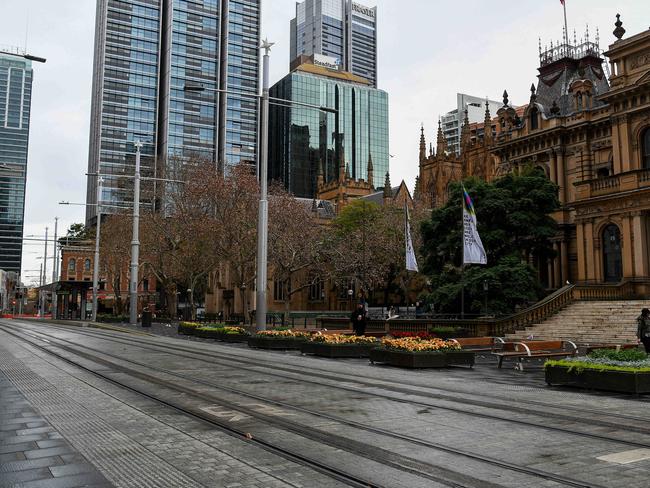 SYDNEY, AUSTRALIA - NewsWire Photos - JULY, 10, 2021: People walk past an empty Town Hall plaza in the CBD of Sydney. New South Wales has recorded 50 new locally transmitted coronavirus cases overnight, 26 of which were infectious during their time in the community. Picture: NCA NewsWire/Bianca De Marchi