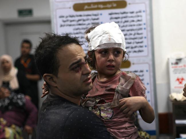 A Palestinian man carries his injured daughter at the Najjar hospital following an Israeli air strike on a home in Rafah, in the southern Gaza Strip. Picture: AFP