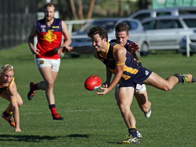 Riddell District Football League, round 5 match was between Diggers Rest and Rupertswood. Diggers Rest won 13.9 (87) to 7.10 (52). Aaron Smith gets a handball clear under the pump from the Burras Brandon Kilty. Picture: Aaron Cook