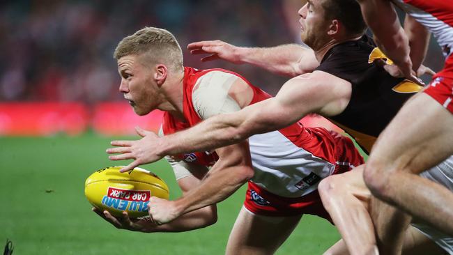 Sydney's Dan Hannebery attempts to handball as Hawthorn's Tom Mitchell tackles him at the SCG. Picture. Phil Hillyard