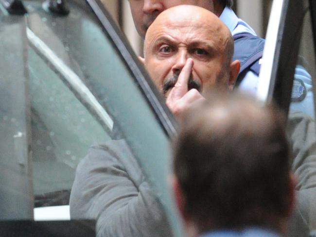 Christopher Binse gestures to the media as he’s led out of the Supreme Court. Picture: AAP