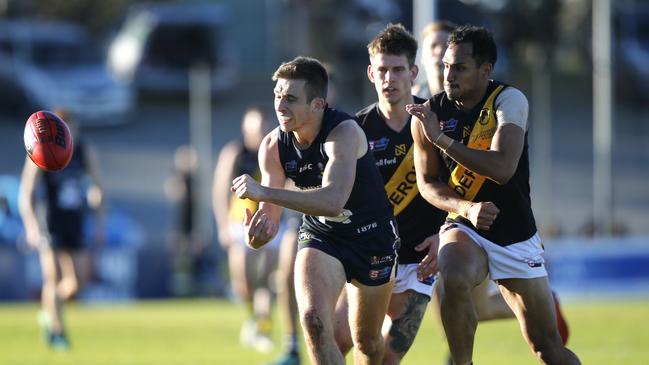 Joel Cross gets a handball away from Marlon Motlop in his 100th game. Picture: CORY SUTTON