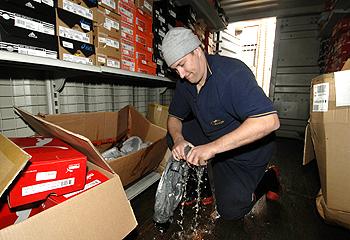 Feeling the squeeze: Brad Duncan wrings water out of sporting goods at his store in Lakes Entrance. Picture: Jay Town