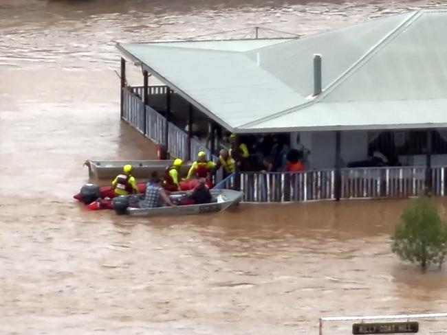 This frame grab taken from video footage provided by The Queensland Fire Department on March 28, 2025 via AFPTV shows rescue workers taking residents from a house on a flooded street in the town of Adavale in southwest Queensland. Whole herds of cattle have drowned in vast inland floods seeping across the Australian outback, officials said on April 1 as the muddy tide drenched an area the size of France. (Photo by Handout / QUEENSLAND FIRE DEPARTMENT / AFP)