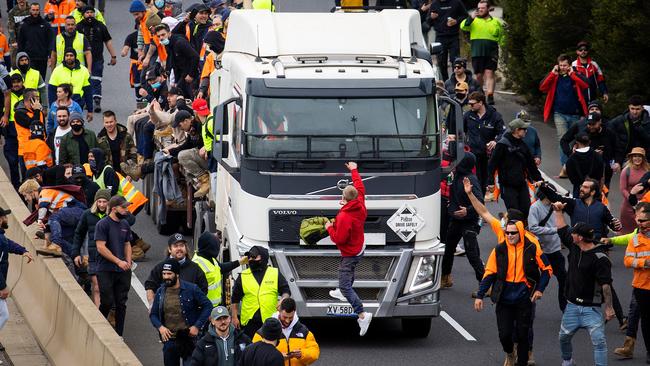 A man climbs on to a truck during the construction worker rally. Picture: Mark Stewart