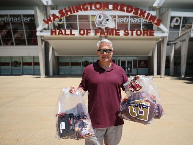 LANDOVER, MARYLAND - JULY 13: Ed Zierle of Annapolis, Maryland, poses with his bags of newly purchased merchandise from the Washington Redskins Hall of Fame Store at FedEx Field July 13, 2020 in Landover, Maryland. A fan of the football team for more than 40 years, Zierle spent several hundred dollars at the store after the team announced Monday that owner Daniel Snyder and coach Ron Rivera are working on finding a replacement for its racist name and logo after 87 years.   Chip Somodevilla/Getty Images/AFP == FOR NEWSPAPERS, INTERNET, TELCOS & TELEVISION USE ONLY ==