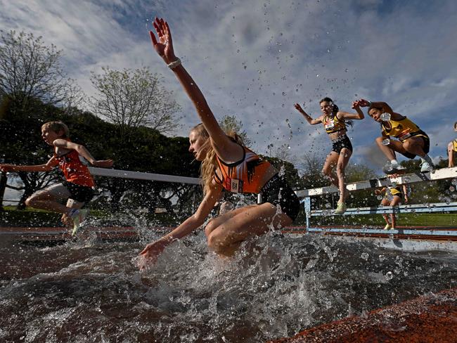 Charlee Dornom, Tilly Williams and Sarah Hastings attempt the water jump during the 2000m Steeplechase during the Athletics Victoria Shield League at Knox Athletics Track. in Knoxfield, Saturday, Oct. 8, 2022. Picture: Andy Brownbill