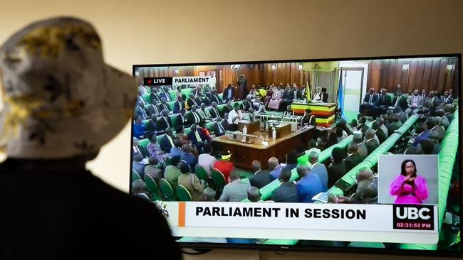 A Ugandan transgender woman who was recently attacked and is being sheltered watches the live broadcast of the session from the parliament for the anti-gay bill in March 2023. Picture: STUART TIBAWESWA / AFP