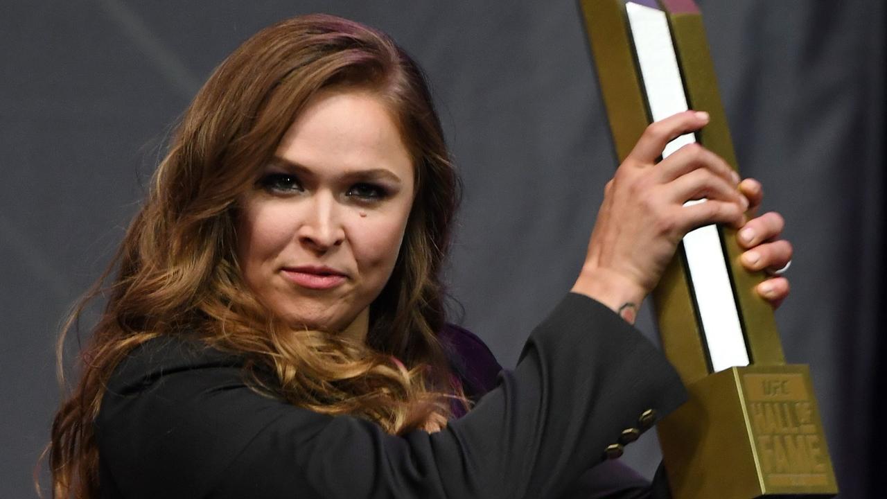Ronda Rousey holds a trophy onstage after becoming the first female inducted into the UFC Hall of Fame. Photo: Ethan Miller/Getty Images/AFP