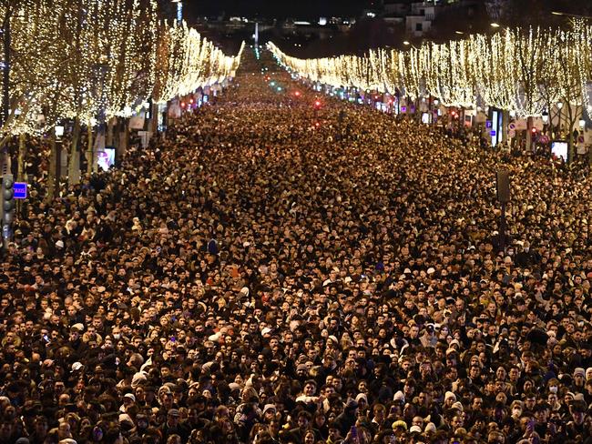 Crowds gather on the Champs-Elysee as they wait for the New Year’s Eve fireworks. Picture: AFP